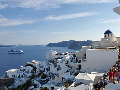 Cruise ship sailing Greek Isles with Santorini backdrop